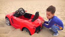 红色小汽车陷在沙滩上了
